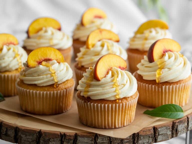 Honey Peach Cream Cheese Cupcakes – The Ultimate Fruity Delight You Must Bake 6 Honey peach cream cheese cupcakes on rustic wooden tray